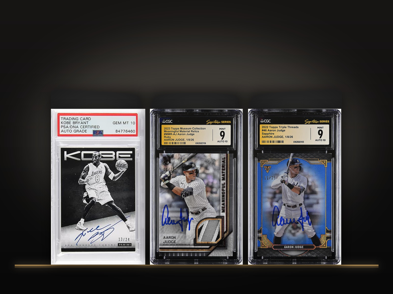 Graded American sports cards from our holdings displayed on a lit glass shelf